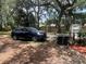 Car parked on land with mature trees, a wooden fence and a storage shed in the background at 578 3Rd St, Daytona Beach, FL 32117