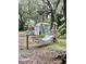 Backyard retreat featuring a hammock, art, storage shed, mature trees, and landscaping at 578 3Rd St, Daytona Beach, FL 32117