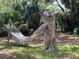 Comfortable backyard hammock for relaxation, enhanced by a unique hand-carved tree stump at 578 3Rd St, Daytona Beach, FL 32117