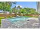Landscaped backyard with a stone patio surrounding a sparkling pool at 624 Richmond Street, Orlando, FL 32806