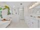 Bright bathroom featuring a soaking tub, glass shower, and double vanity sink at 624 Richmond Street, Orlando, FL 32806