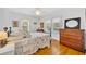 Bedroom featuring hardwood floors, two windows, and an antique dresser with mirror at 624 Richmond Street, Orlando, FL 32806