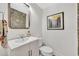 Charming powder room featuring patterned wallpaper, and a framed mirror above a vessel sink at 624 Richmond Street, Orlando, FL 32806