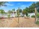 This beautiful backyard features a firepit, crushed rock, mature trees and an arbor leading to an entertaining area at 6501 Matchett Rd, Belle Isle, FL 32809