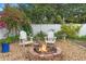 A close up of the backyard brick fire pit with Adirondack chairs surrounded by lush landscaping at 6501 Matchett Rd, Belle Isle, FL 32809