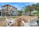 Wide backyard view with a fire pit, crushed rock, seating and an arbor with string lights overhead at 6501 Matchett Rd, Belle Isle, FL 32809