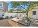 Backyard patio with lounge chairs under a striped umbrella surrounded by landscaping at 6501 Matchett Rd, Belle Isle, FL 32809