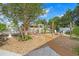 This beautiful backyard features a firepit, crushed rock, mature trees and an arbor leading to an entertaining area at 6501 Matchett Rd, Belle Isle, FL 32809
