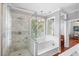 Elegant bathroom featuring walk-in shower and soaking tub with natural light at 6501 Matchett Rd, Belle Isle, FL 32809