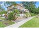 Lovely stone home with a cozy covered porch, lush landscaping, and a sidewalk leading to the entrance at 6501 Matchett Rd, Belle Isle, FL 32809