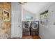 Well-lit laundry room with modern washer and dryer and unique stone wall at 6501 Matchett Rd, Belle Isle, FL 32809