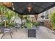 A covered patio area is well decorated with multiple plants, seating, hanging pendant light and a grill at 6501 Matchett Rd, Belle Isle, FL 32809