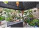 A covered patio area is well decorated with multiple plants, seating, hanging pendant light and a gas fire pit at 6501 Matchett Rd, Belle Isle, FL 32809