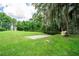 Backyard with a concrete dock and lush greenery leading to a tranquil waterfront at 6720 Winter Garden Vineland Rd, Windermere, FL 34786