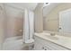 Cozy bathroom featuring a shower-tub combo, single sink vanity, and neutral tile at 6720 Winter Garden Vineland Rd, Windermere, FL 34786
