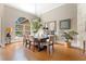 Elegant dining room with a wooden table set, arched window, and views of the backyard at 6720 Winter Garden Vineland Rd, Windermere, FL 34786