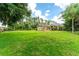 Well manicured expansive front yard with a charming home nestled among mature trees and manicured landscaping at 6720 Winter Garden Vineland Rd, Windermere, FL 34786