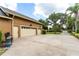 Spacious three-car garage with ample parking and a well-manicured lawn leading to an inviting entrance at 6720 Winter Garden Vineland Rd, Windermere, FL 34786