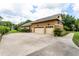 Extended three-car garage showcasing stonework accents with ample driveway space and mature landscaping at 6720 Winter Garden Vineland Rd, Windermere, FL 34786