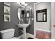 Stylish powder room with a pedestal sink, modern mirror, and elegant wall decor at 806 Spring Island Way, Orlando, FL 32828