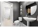 Stylish half-bathroom with dark gray walls, tile floors, and a unique, round mirror over a pedestal sink at 806 Spring Island Way, Orlando, FL 32828