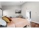Comfortable bedroom with hardwood floors, a seating area, a mounted television, and an ensuite bathroom at 806 Spring Island Way, Orlando, FL 32828