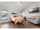 Bright and airy bedroom with hardwood floors, a comfortable bed, a cozy sitting area, and plenty of natural light at 806 Spring Island Way, Orlando, FL 32828