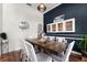 This elegant dining room features a wooden table with seating for eight under a modern pendant light and a built-in display case at 806 Spring Island Way, Orlando, FL 32828