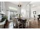 A bright dining room features hardwood floors, a large window, and a modern light fixture creating a welcoming atmosphere at 806 Spring Island Way, Orlando, FL 32828