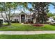 Beautiful home showcasing a lush green lawn, mature trees, and a welcoming front entrance at 806 Spring Island Way, Orlando, FL 32828