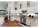 Modern kitchen features white cabinets, stainless steel appliances and hardwood flooring at 806 Spring Island Way, Orlando, FL 32828