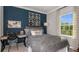 Cozy bedroom features blue accent wall, neutral decor, study desk, and natural light at 862 Junonia Blvd, New Smyrna Beach, FL 32168