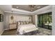 Cozy main bedroom with decorative headboard, modern ceiling fan, accent lighting and large window at 862 Junonia Blvd, New Smyrna Beach, FL 32168