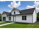 Modern farmhouse with white siding, black roof, and well-manicured lawn presents a striking exterior at 9659 Midway Rd, Haines City, FL 33844