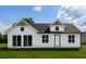 Stylish modern farmhouse featuring white board and batten siding, dark roof, and expansive front lawn at 9659 Midway Rd, Haines City, FL 33844