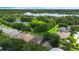 Aerial view of the property surrounded by mature trees and landscaping, with a glimpse of a nearby lake at 985 N Lake Claire Cir, Oviedo, FL 32765