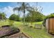 Expansive backyard featuring a lush lawn, garden beds, and views of the screened-in pool enclosure at 985 N Lake Claire Cir, Oviedo, FL 32765