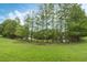 Lush green backyard with mature trees, offering privacy and a peaceful setting with lake views at 985 N Lake Claire Cir, Oviedo, FL 32765
