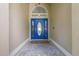 Inviting entryway showcasing a vibrant blue front door with decorative glass and stylish stone flooring at 985 N Lake Claire Cir, Oviedo, FL 32765