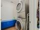 Efficient laundry room featuring a stacked washer and dryer and storage cabinet at 985 N Lake Claire Cir, Oviedo, FL 32765