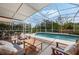 Inviting screened-in pool area surrounded by lush landscaping and comfortable seating at 985 N Lake Claire Cir, Oviedo, FL 32765