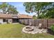 Serene backyard with a fire pit, patio seating, a privacy fence, and a well-maintained lawn at 102 Sand Pine Cir, Sanford, FL 32773