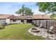 Spacious backyard featuring a stone fire pit area, lush lawn, and access to the home and lanai at 102 Sand Pine Cir, Sanford, FL 32773