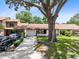 Inviting townhomes featuring attached garages and well-manicured lawns under a shade tree at 102 Sand Pine Cir, Sanford, FL 32773