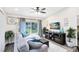 Inviting living room with a plush sectional couch, a ceiling fan, and a large window view of the backyard at 102 Sand Pine Cir, Sanford, FL 32773