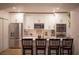 Modern white kitchen featuring stainless steel appliances, a breakfast bar, and stylish barstools at 112 Avocado Ave, Sanford, FL 32771