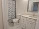 Well-lit bathroom featuring a modern vanity, patterned shower curtain, and elegant marble flooring at 13546 Summerton Dr, Orlando, FL 32824