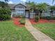 Charming townhome with a well-manicured front yard, landscaped with colorful plants and mulch, leading to the front door at 13546 Summerton Dr, Orlando, FL 32824