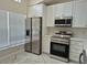 Modern kitchen with stainless steel appliances, white cabinetry, and ample natural light from the window at 13546 Summerton Dr, Orlando, FL 32824