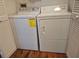 Laundry room features a white washer and dryer, surrounded by closet doors and wood floors at 13546 Summerton Dr, Orlando, FL 32824